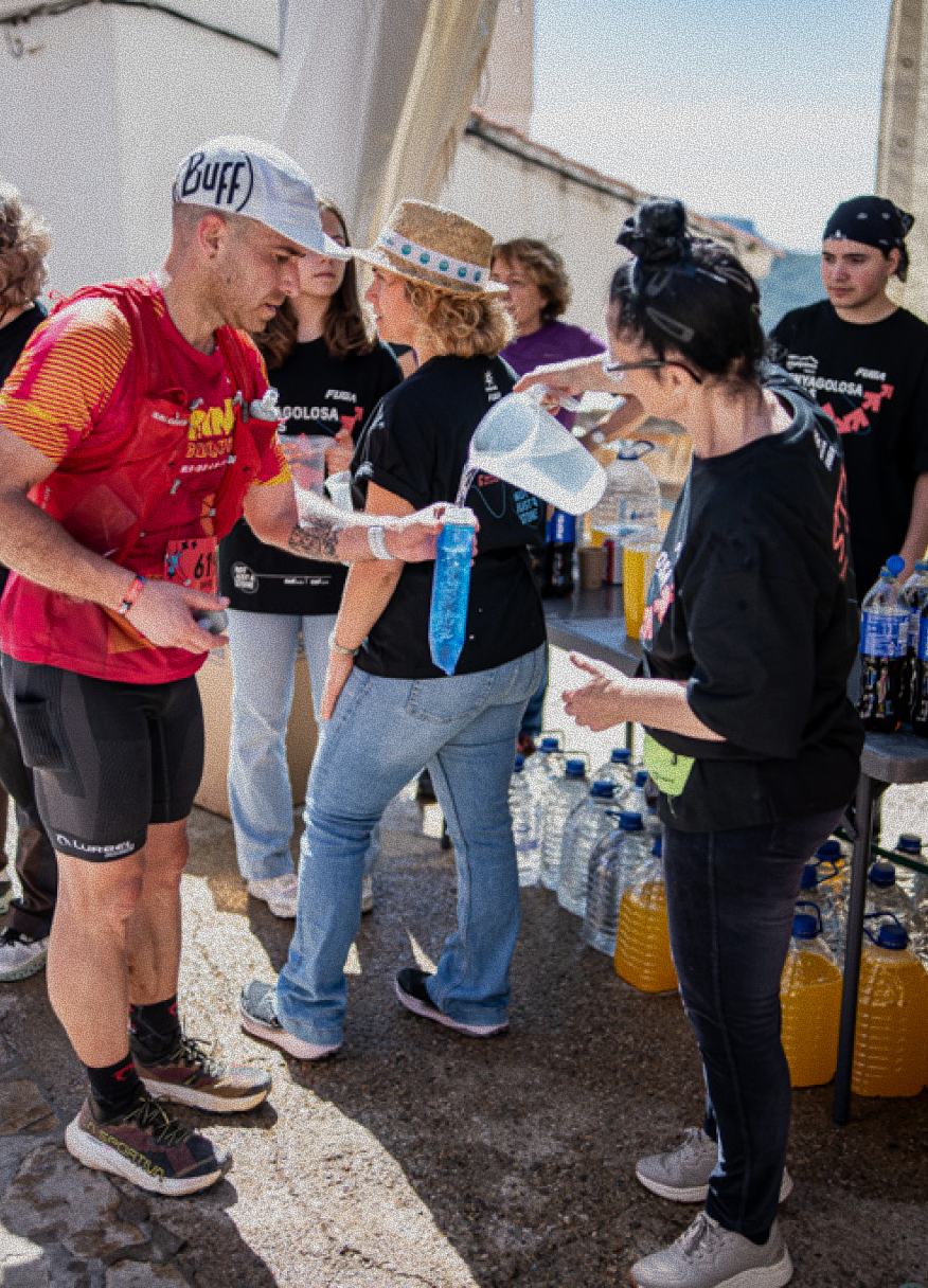 Voluntarias sirviendo bebida a los corredores al aire libre